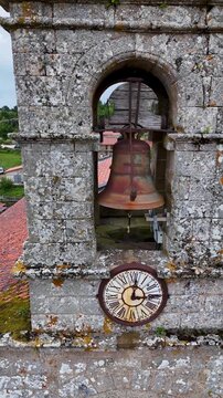 Drone flying away from ancient Santa Marina de Augas Santas church clock tower