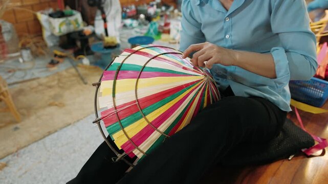 Vietnam artisan making a traditional conical hat in a workshop, showcasing local craftsmanship and culture