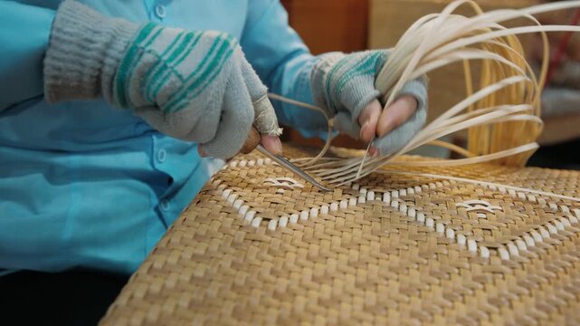 Vietnam artisan skillfully weaving wicker chair seat in a workshop