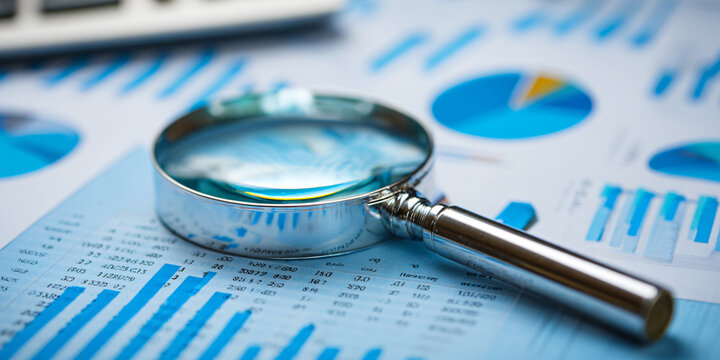 Magnifying Glass Over Financial Data Report with Calculator