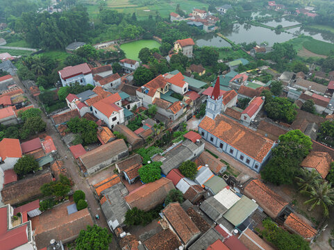 Drone perspective of Duong Lam Ancient Village featuring village church, narrow roads, and dense traditional residential rooftops.