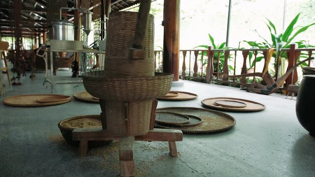 Traditional vietnam rice milling machine used for hulling paddy grains in a rustic wooden workshop