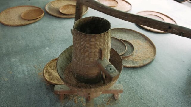 Traditional vietnam rice milling machine used for hulling paddy grains in a rustic wooden workshop