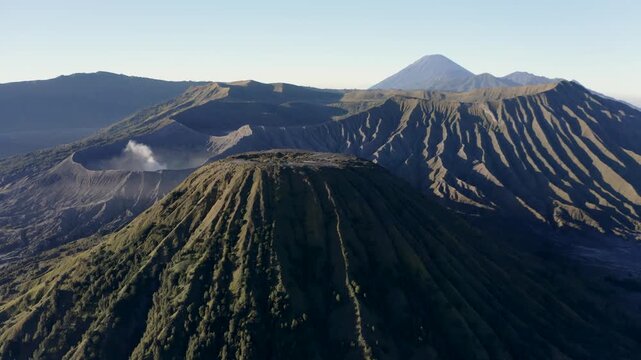 Aerial view of Mount Bromo volcanic craters with steam rising against a clear sky in Tosari, East Java, Indonesia.