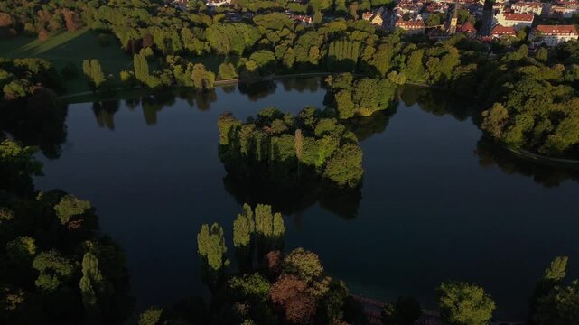 Aerial view of Kleinhesseloher See in the English Garden, Munich, Germany. Famous Bavarian park with lake, islands, nature and culture. Popular summer destination in central Europe