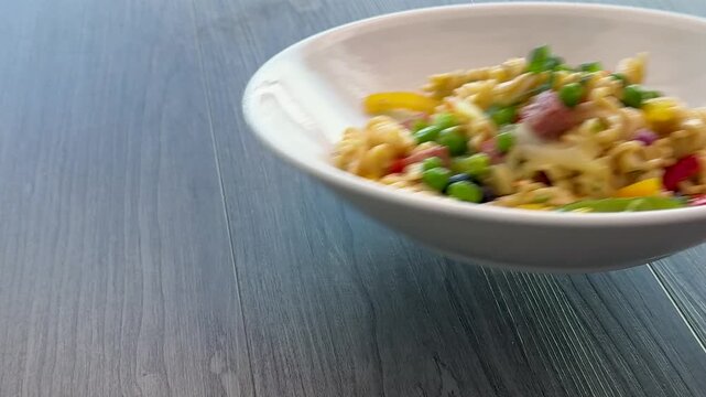 Serving a Bowl of Pasta Salad with Peas, Peppers and Ham