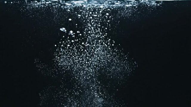 Air bubbles rising in clear water on black background, slow motion footage for video backdrop