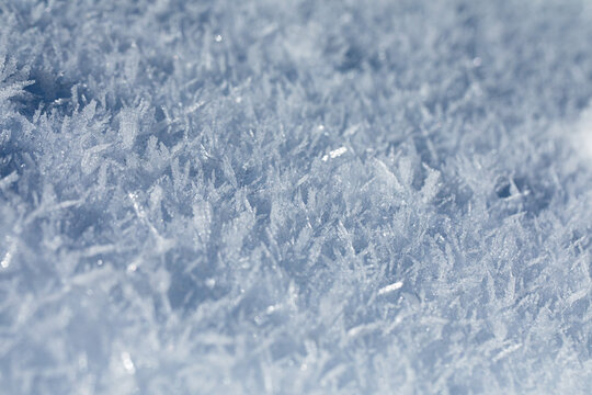 superficie coperta da bellissimi cristalli di neve ghiacciata dalle tonalit&agrave; di azzurro, foto con vista macro