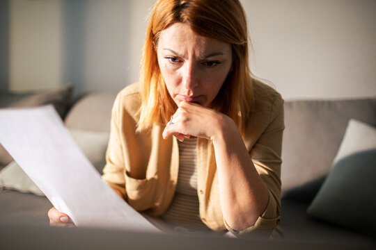 Concerned woman reviewing bills at home