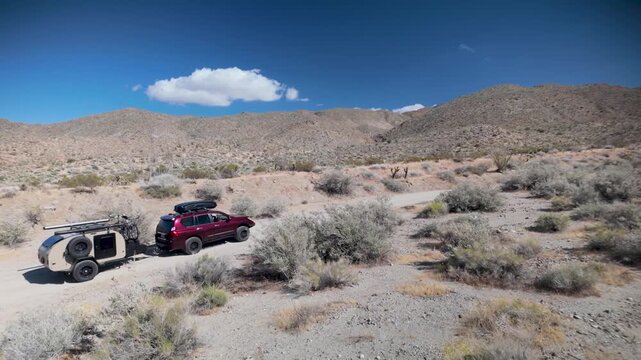 Aerial views show a teardrop camper and SUV navigating the desert trails in Anza Borego State Park and Prune Canyon in California.