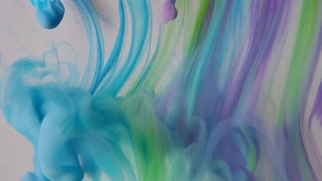 Abstract Macro Footage of Blue Green and Purple Ink Clouds Swirling in Water
