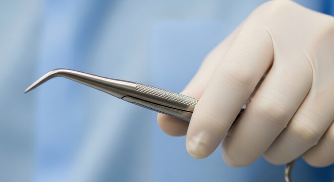 Medical tweezers held by a gloved hand
