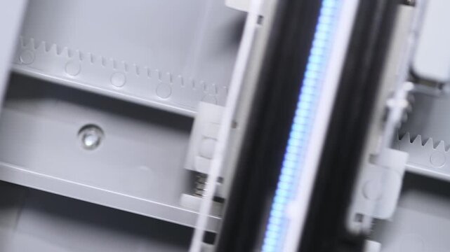 Close up detailed view of flatbed scanner internal mechanism with measurement scale and lighting