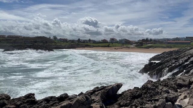 Atlantic surf rolling onto sandy shoreline with foamy ocean water beneath dramatic moving clouds