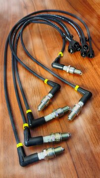 Vertical video social media - Closeup of a new set of six spark plugs, attached to high voltage leads, cables or wires, for a vehicle ignition system.