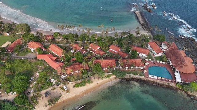 Aerial View Above Dickwella Bay Tropical Coastline Sri Lanka
Aerial drone footage above Dickwella Bay resort coastline and turquoise ocean Sri Lanka May 2026.
