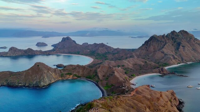 Aerial view of Padar Island in Komodo National Park featuring rugged hills and turquoise bays under a soft morning sky East Nusa Tenggara, Indonesia.