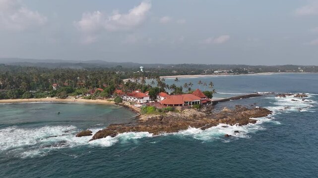 Aerial View Above Dickwella Bay Tropical Coastline Sri Lanka
Aerial drone footage above Dickwella Bay resort coastline and turquoise ocean Sri Lanka May 2026.
