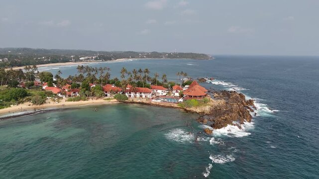Aerial View Above Dickwella Bay Tropical Coastline Sri Lanka
Aerial drone footage above Dickwella Bay resort coastline and turquoise ocean Sri Lanka May 2026.
