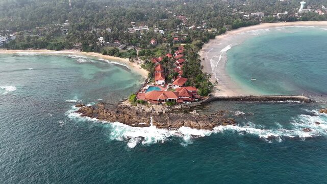 Aerial View Above Dickwella Bay Tropical Coastline Sri Lanka
Aerial drone footage above Dickwella Bay resort coastline and turquoise ocean Sri Lanka May 2026.
