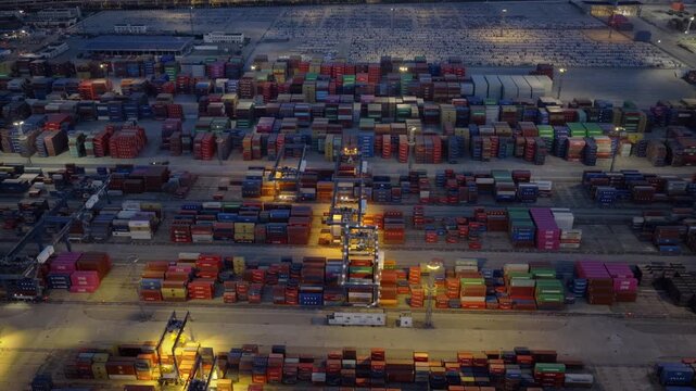 Illuminated container terminal and cargo yard at night from aerial perspective
