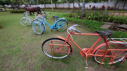 Obraz premium Colorful Vintage Bicycles Displayed in Garden Park