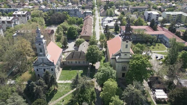 Drone tracking shot over historic town buildings and old churches in Vrbas town center, northern Serbia.