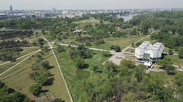 Lateral drone flight showing lush greenery of Usce Park in New Belgrade, Serbia.