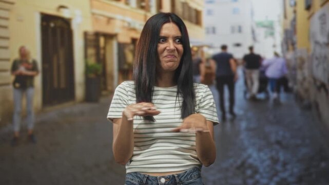 Woman crossing arms with hands held forward in a refusal gesture on a crowded cobblestone street with pedestrians and buildings; disgust rejection.