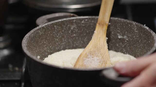 Cooking ghomi, a popular dish from the Samegrelo region made with coarse white corn flour