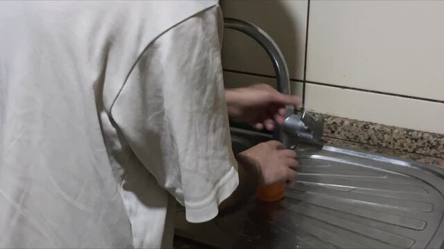 Depression Symptoms in Domestic Neglect: Cluttered Kitchen Sink with Unwashed Glasses, Sponge and Cutting Board Chaos