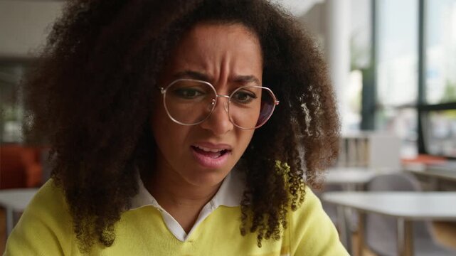 Confused puzzled African American woman student girl looking in laptop screen feeling shock female look in computer annoyed reaction studying difficulty problem e-learning in high school university