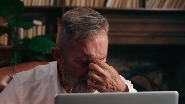 Caucasian retired senior old business man taking off eyeglasses feeling eyes pain headache working laptop discomfort vision aged elderly businessman male dry eye computer irritated eyesight at office