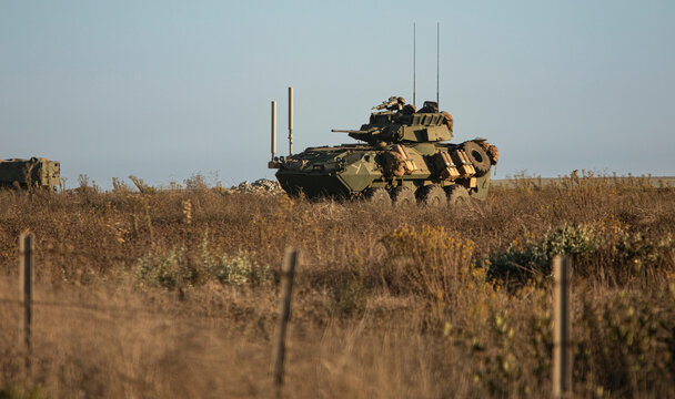 Side view of a United States Marine amphibious combat vehicle training in a field