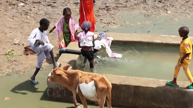 Drone view of village children drinking water beside animal trough, April 25, 2026, Chad, N Djamena