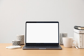 Fototapeta premium Stylish workplace with laptop, stationery, cup and decor indoors