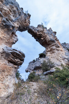 Natural rock arch forming a geological bridge in canyon