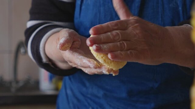 Woman hands forming cottage cheese pancake syrniki, traditional home cooking process of making dough, culinary preparation of fresh dairy breakfast in a rustic domestic kitchen room