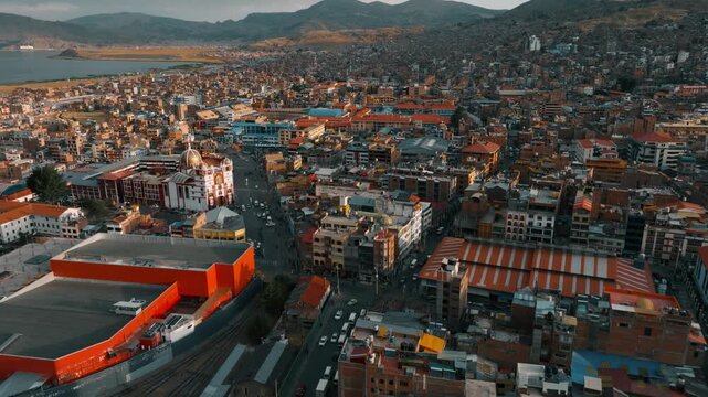 Drone aerial view of Puno, a historic city located on the shores of Lake Titicaca in southern Peru. Urban neighborhoods, Andean hills, and the vast waters of the world&rsquo;s highest navigable lake create 