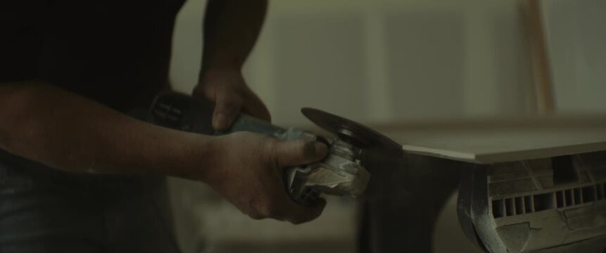 Close-up of a contractor using a power tool during interior construction or home renovation work with cinematic warm lighting and shallow depth of field.