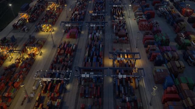 Aerial night view of illuminated cargo container terminal at busy seaport