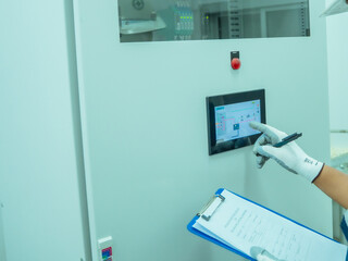 Fototapeta premium Close up hand engineer checklist continuous emission monitoring system in control electric power at factory. Technician analysis management air pollution reduction system industrial. Environment work