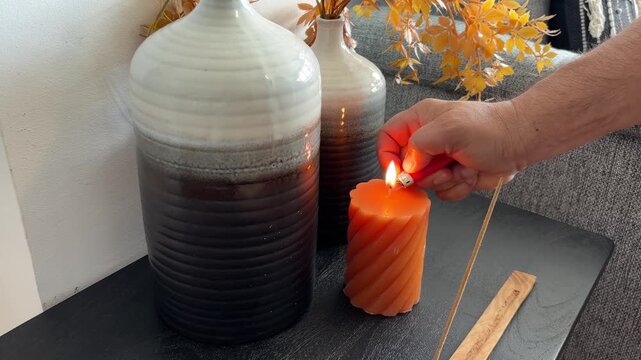 Mano de hombre encendiendo una vela creando espacio zen
