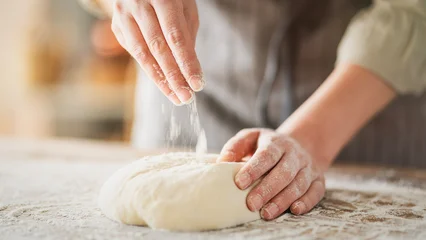 Fotobehang Bakkerij Kneading dough at the kitchen table  © sebra