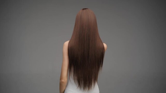 Woman Flipping Long Straight Brown Hair from Back View
