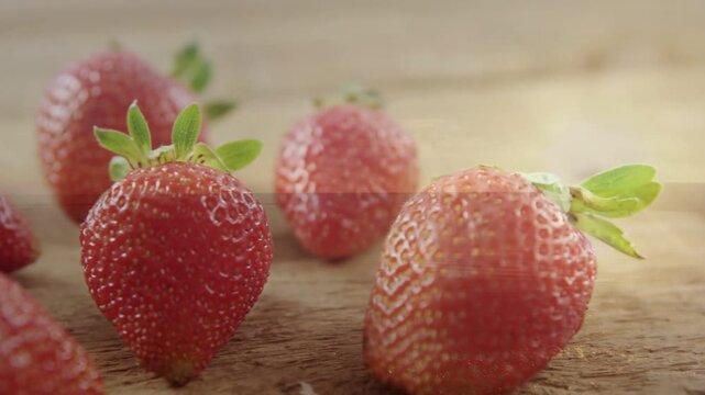 Slow leftward camera slide initiating rack focus, strawberry shifting to center, showcasing texture