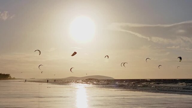 Group of Kitesurfers on the Ocean at Sunset with Dunes and Golden Light, Prea, Brazil