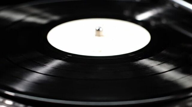Close-up of a vinyl record on a turntable. Soft focus. Black with white label