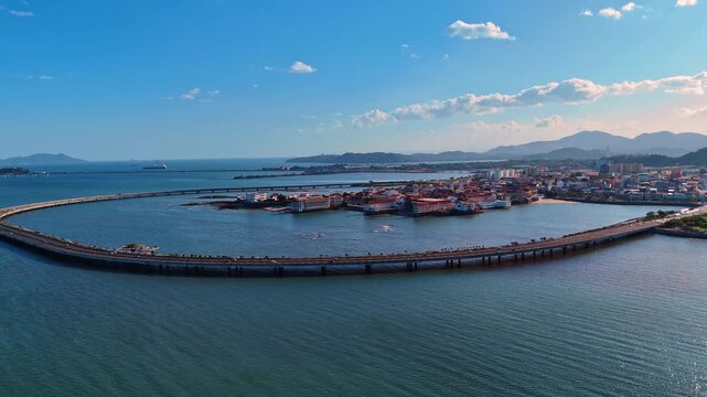 Casco Viejo and coastal highway in evening light. Aerial view of Casco Viejo, curved coastal highway, bay water, hills and warm evening sky