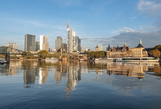 Excursion boats on the river bank, view over the Main, skyline reflected in the river, skyscrapers in the banking district in the morning light, Frankfurt am Main, Hesse, Germany